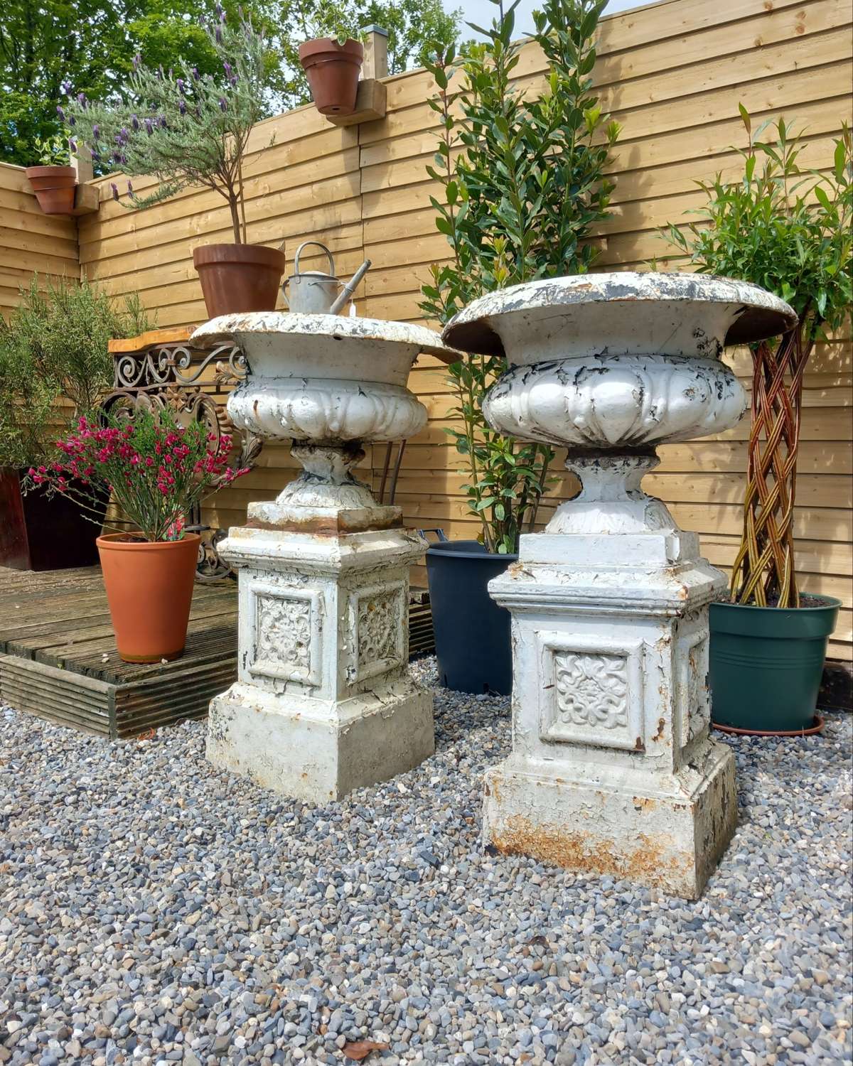 Near pair of 19th century cast iron urns on pedestals